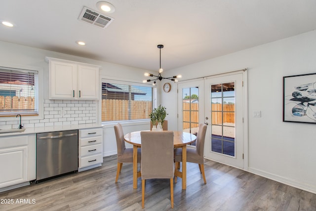 dining room with a chandelier, light wood-style floors, recessed lighting, baseboards, and french doors
