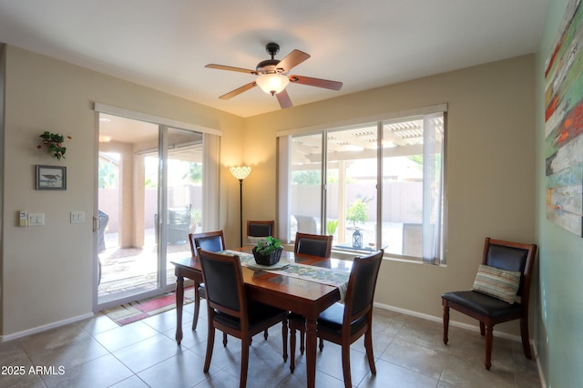 dining room with a wealth of natural light, ceiling fan, and light tile patterned flooring