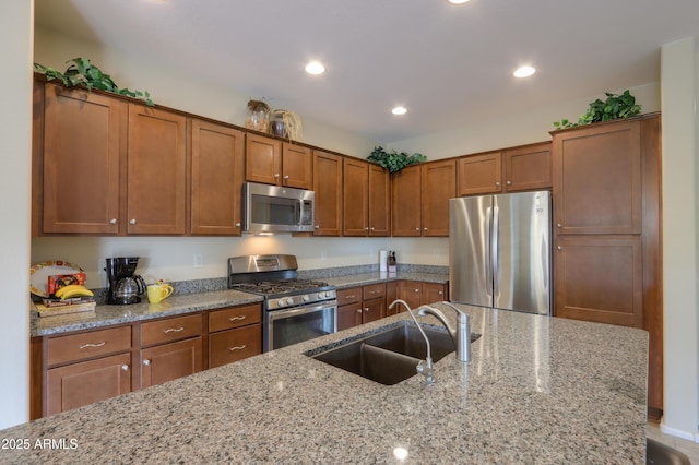 kitchen featuring light stone counters, appliances with stainless steel finishes, and sink