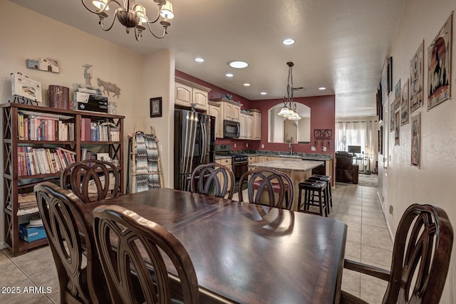 tiled dining space with sink and an inviting chandelier