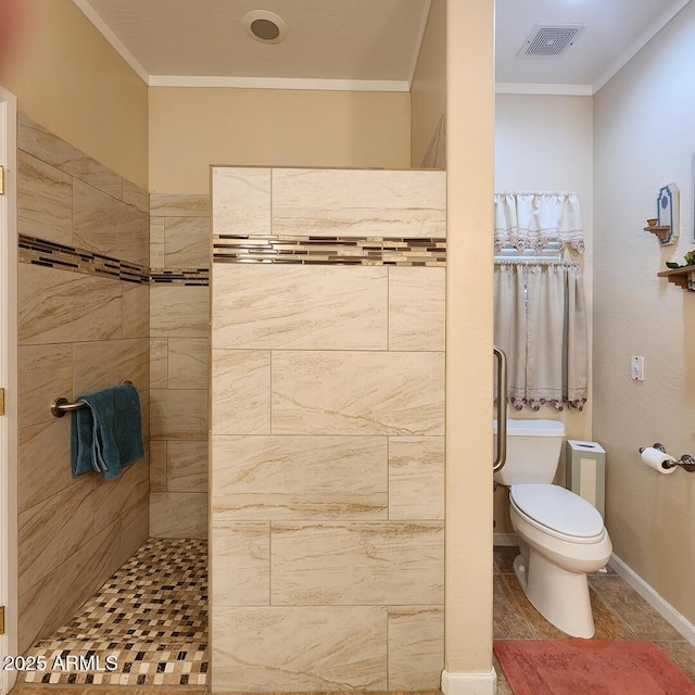 bathroom with toilet, a tile shower, and ornamental molding