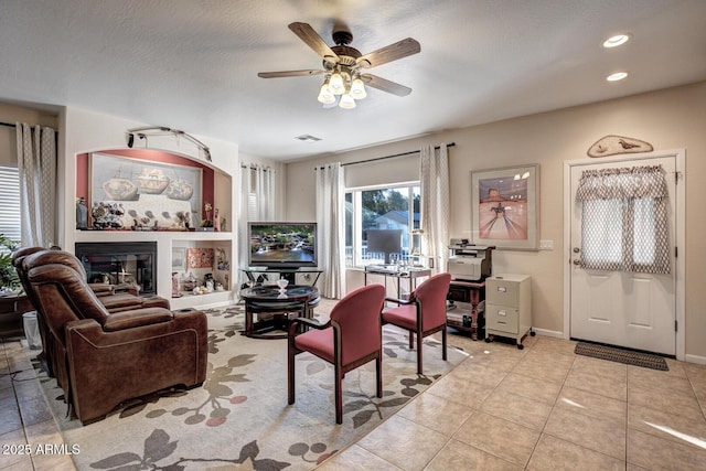 tiled living room featuring a textured ceiling and ceiling fan