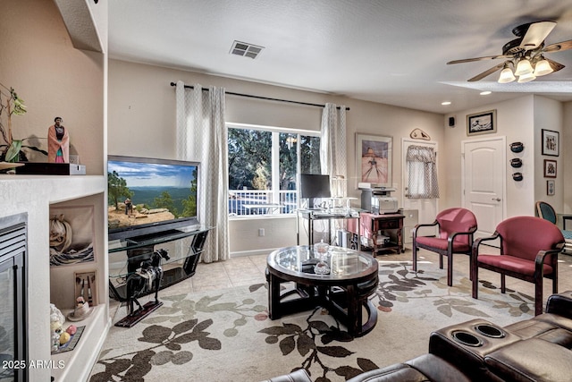 living room with ceiling fan, a textured ceiling, and light tile patterned floors