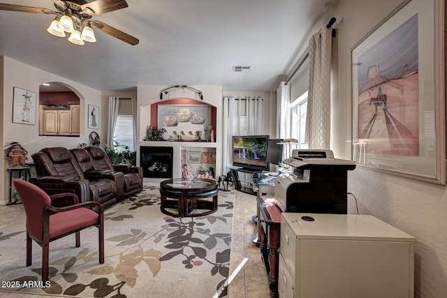 tiled living room with ceiling fan and a healthy amount of sunlight