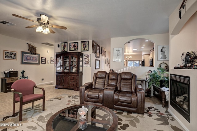 living room featuring light tile patterned floors and ceiling fan with notable chandelier