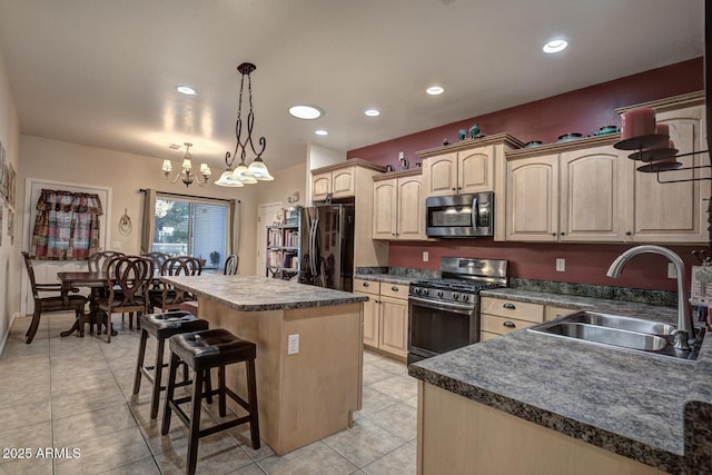 kitchen featuring decorative light fixtures, a notable chandelier, a center island, sink, and appliances with stainless steel finishes