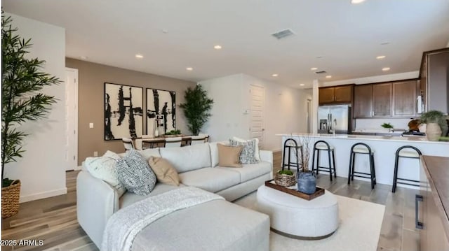 23334 W Mobile Ln, Buckeye, AZ 85326 - living room featuring light wood-type flooring, recessed lighting, and baseboards
