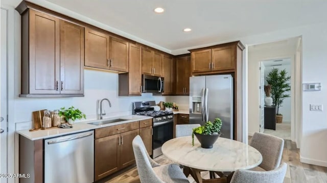 23334 W Mobile Ln, Buckeye, AZ 85326 - kitchen featuring appliances with stainless steel finishes, a sink, light countertops, recessed lighting, and light wood-style floors