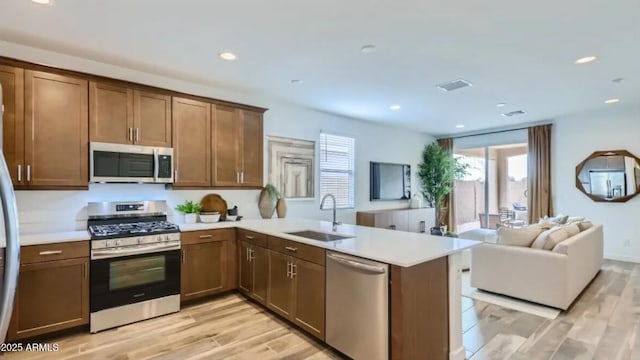 23334 W Mobile Ln, Buckeye, AZ 85326 - kitchen featuring stainless steel appliances, a sink, a peninsula, open floor plan, and light countertops