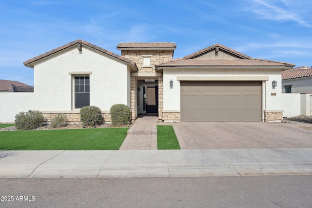 view of front of house with stone siding, decorative driveway, an attached garage, and a tile roof