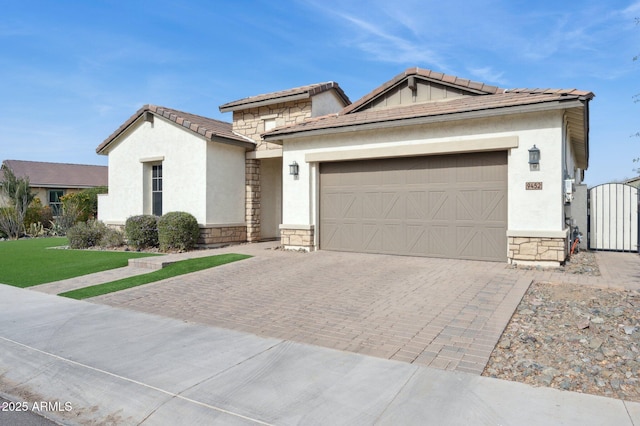 view of front facade featuring stone siding, decorative driveway, an attached garage, and stucco siding