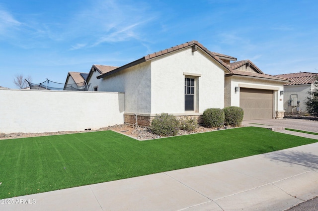 view of side of home featuring driveway, stone siding, a lawn, and stucco siding