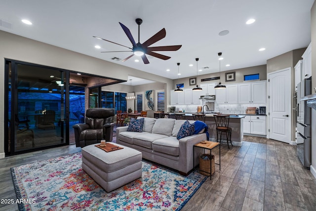 living area featuring recessed lighting, dark wood-style floors, visible vents, and ceiling fan