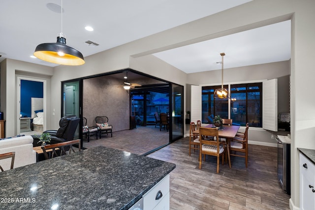 kitchen with visible vents, open floor plan, wood finished floors, white cabinetry, and hanging light fixtures