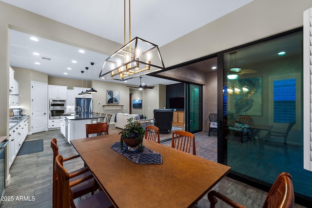 dining area featuring dark wood finished floors, visible vents, recessed lighting, and ceiling fan with notable chandelier