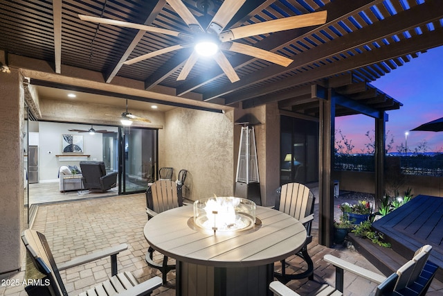 view of patio with outdoor dining area, a ceiling fan, and a pergola