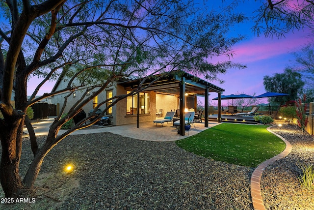 yard at dusk with a patio area and a fenced backyard