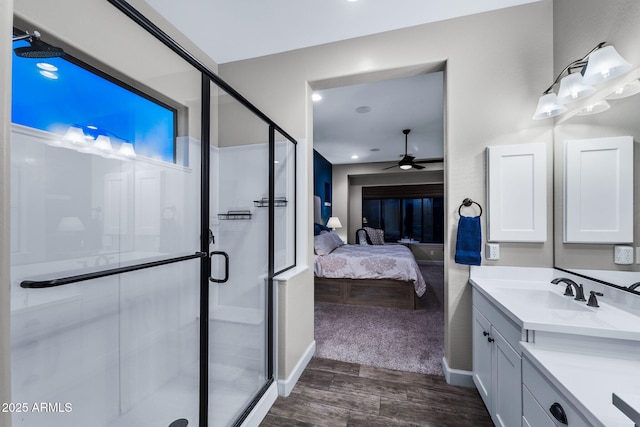 ensuite bathroom featuring vanity, wood finished floors, a stall shower, ceiling fan, and ensuite bathroom