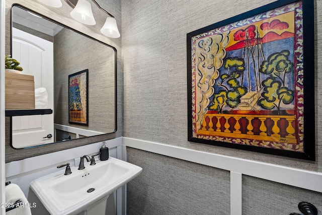 bathroom featuring a sink and wallpapered walls