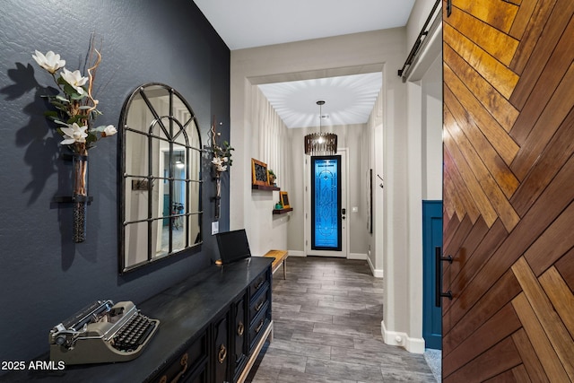 entryway with a barn door, baseboards, and dark wood-style flooring