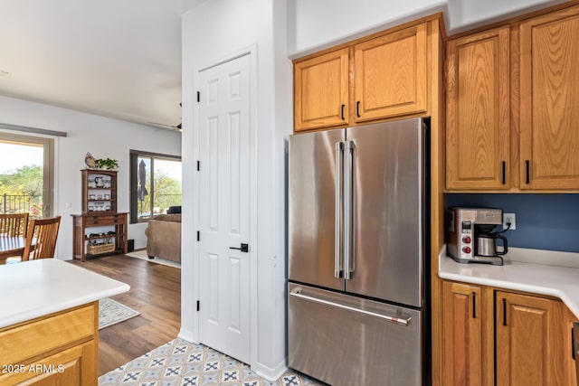 kitchen with brown cabinetry, high end refrigerator, and light countertops