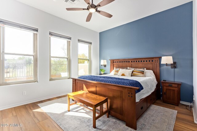 bedroom with visible vents, baseboards, wood finished floors, and a ceiling fan