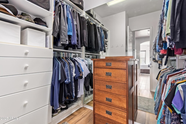 spacious closet featuring arched walkways and wood finished floors