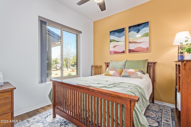 bedroom with wood finished floors, baseboards, and ceiling fan