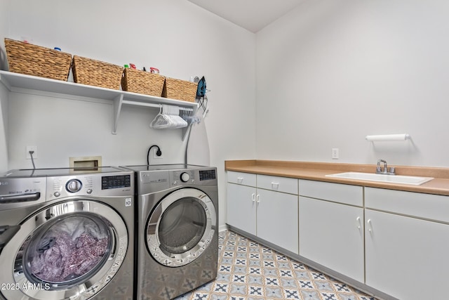 washroom with cabinet space, separate washer and dryer, light floors, and a sink