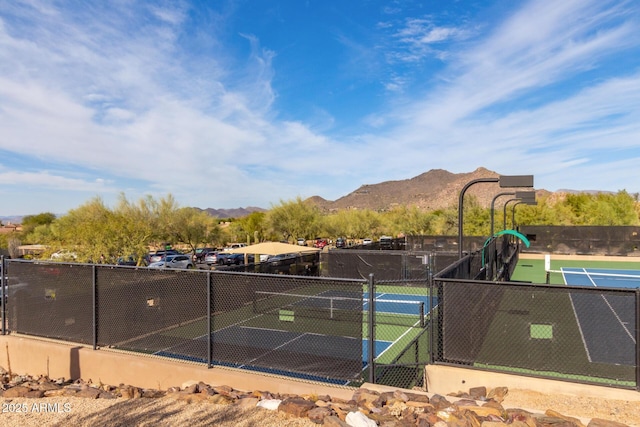 view of sport court featuring fence and a mountain view