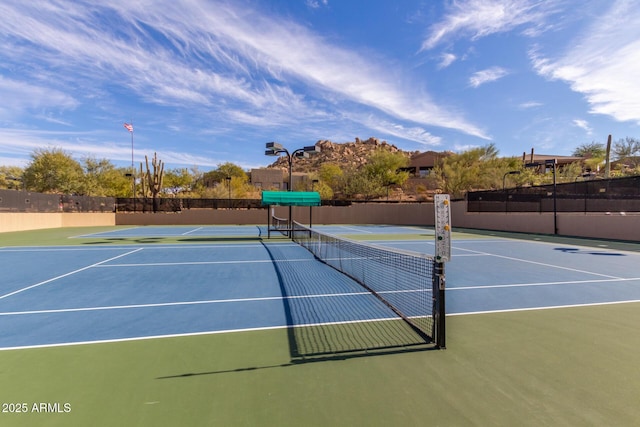 view of tennis court featuring fence