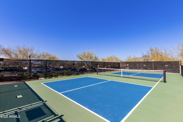 view of tennis court with community basketball court and fence