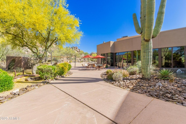 view of property's community featuring outdoor dining area and a patio