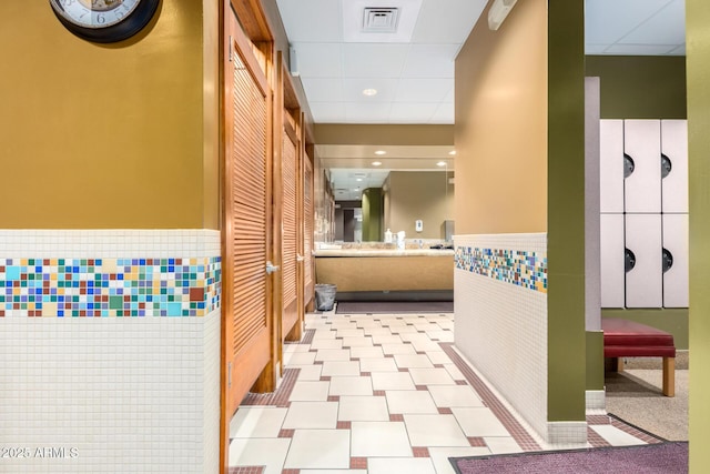 bathroom featuring visible vents, tile walls, wainscoting, a paneled ceiling, and vanity