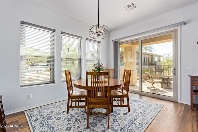 dining room with visible vents, baseboards, an inviting chandelier, and wood finished floors