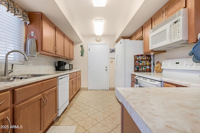 kitchen with white appliances, sink, light tile patterned floors, and tasteful backsplash