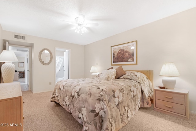 bedroom with light colored carpet, ensuite bath, and ceiling fan