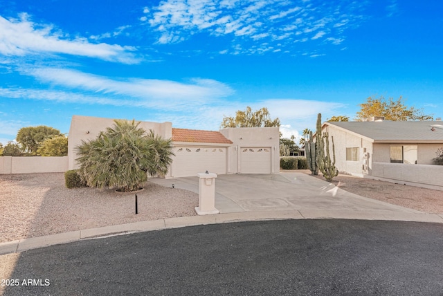 pueblo revival-style home featuring a garage