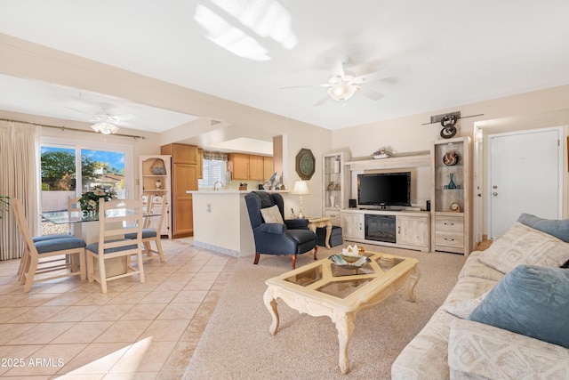 tiled living room featuring ceiling fan and sink