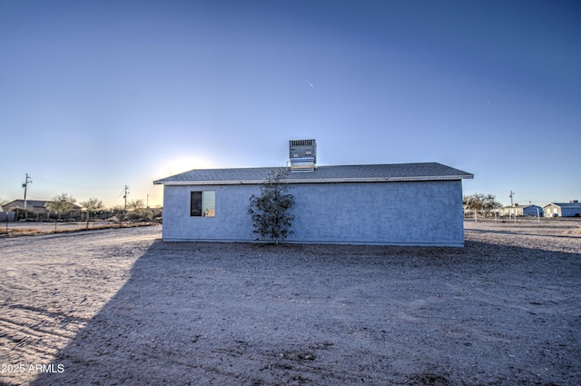 view of side of home with stucco siding and central AC