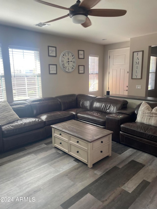 living room with wood-type flooring, ceiling fan, and a healthy amount of sunlight