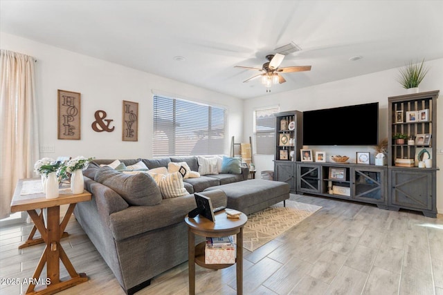 living area with visible vents, light wood-type flooring, and ceiling fan