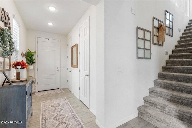 entrance foyer featuring stairway, recessed lighting, light wood-style floors, and baseboards