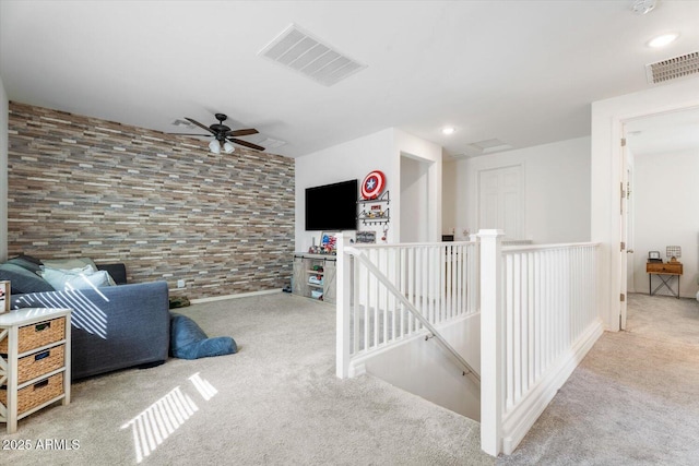 interior space featuring an upstairs landing, visible vents, recessed lighting, and carpet floors