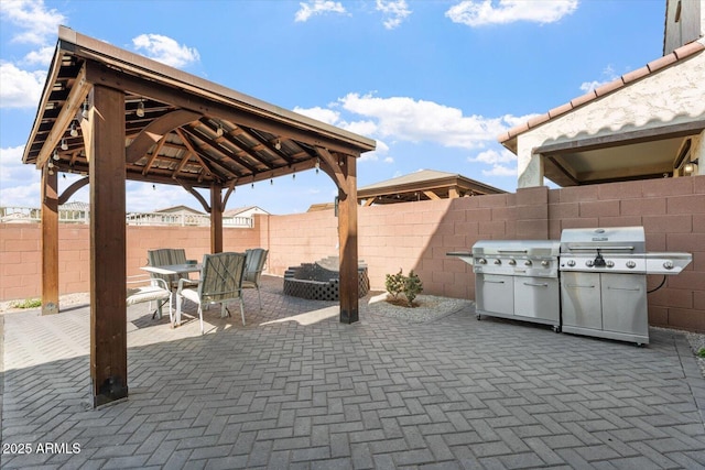 view of patio featuring a gazebo, a grill, a fenced backyard, and outdoor dining space