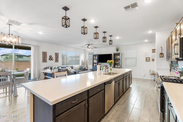 kitchen with visible vents, dark brown cabinetry, appliances with stainless steel finishes, light countertops, and hanging light fixtures