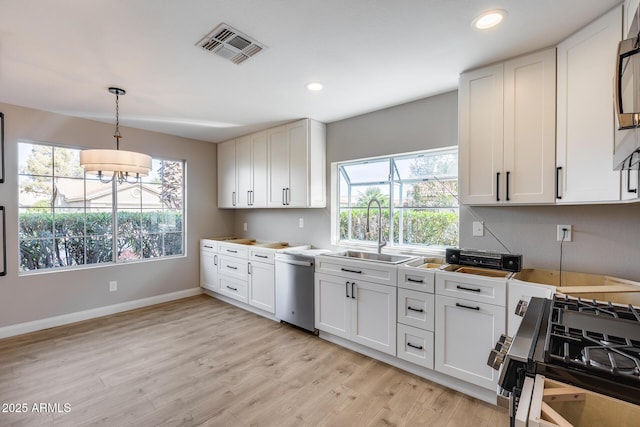 kitchen featuring a sink, visible vents, stainless steel dishwasher, light wood-type flooring, and gas range