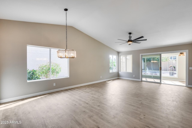 spare room featuring lofted ceiling, plenty of natural light, and wood finished floors