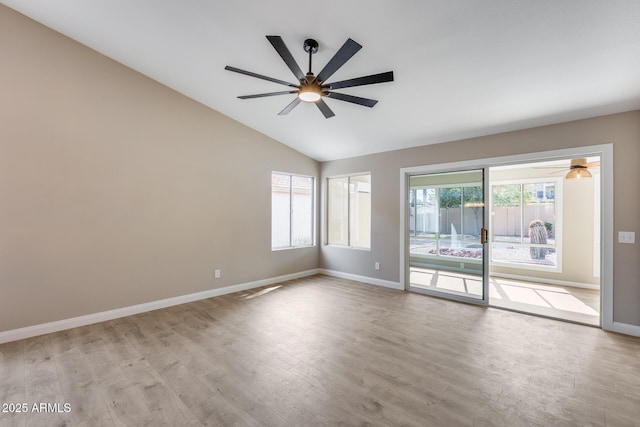 empty room with lofted ceiling, ceiling fan, baseboards, and wood finished floors