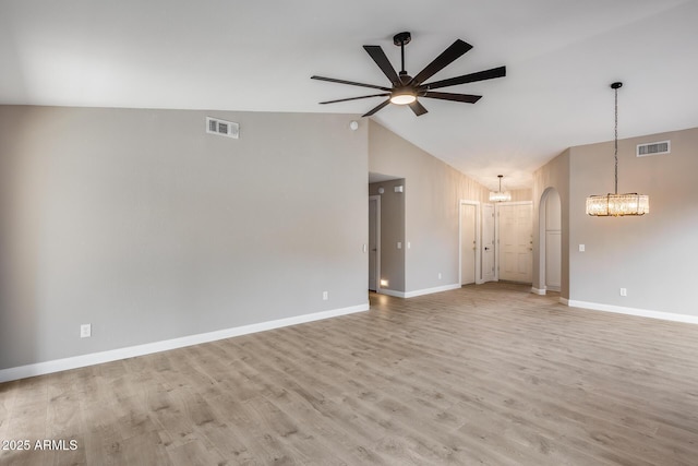 interior space with light wood-style floors, arched walkways, visible vents, and ceiling fan with notable chandelier